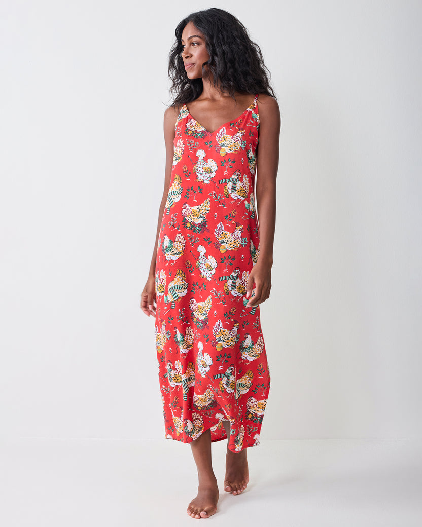 Front view of a model wearing the red Holiday Hens nightie with a V-neck, thin straps, midi length, and printed hen pattern.