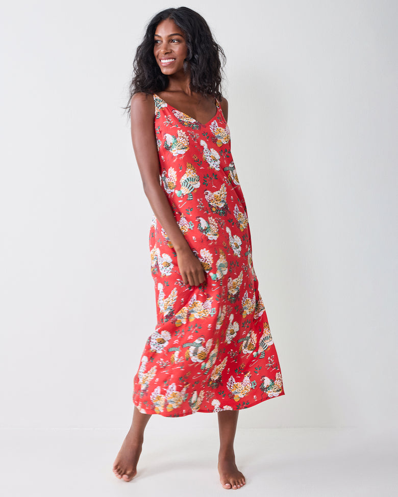 Full-body view of a model wearing the red Holiday Hens midi nightie with thin straps and a printed hen pattern.