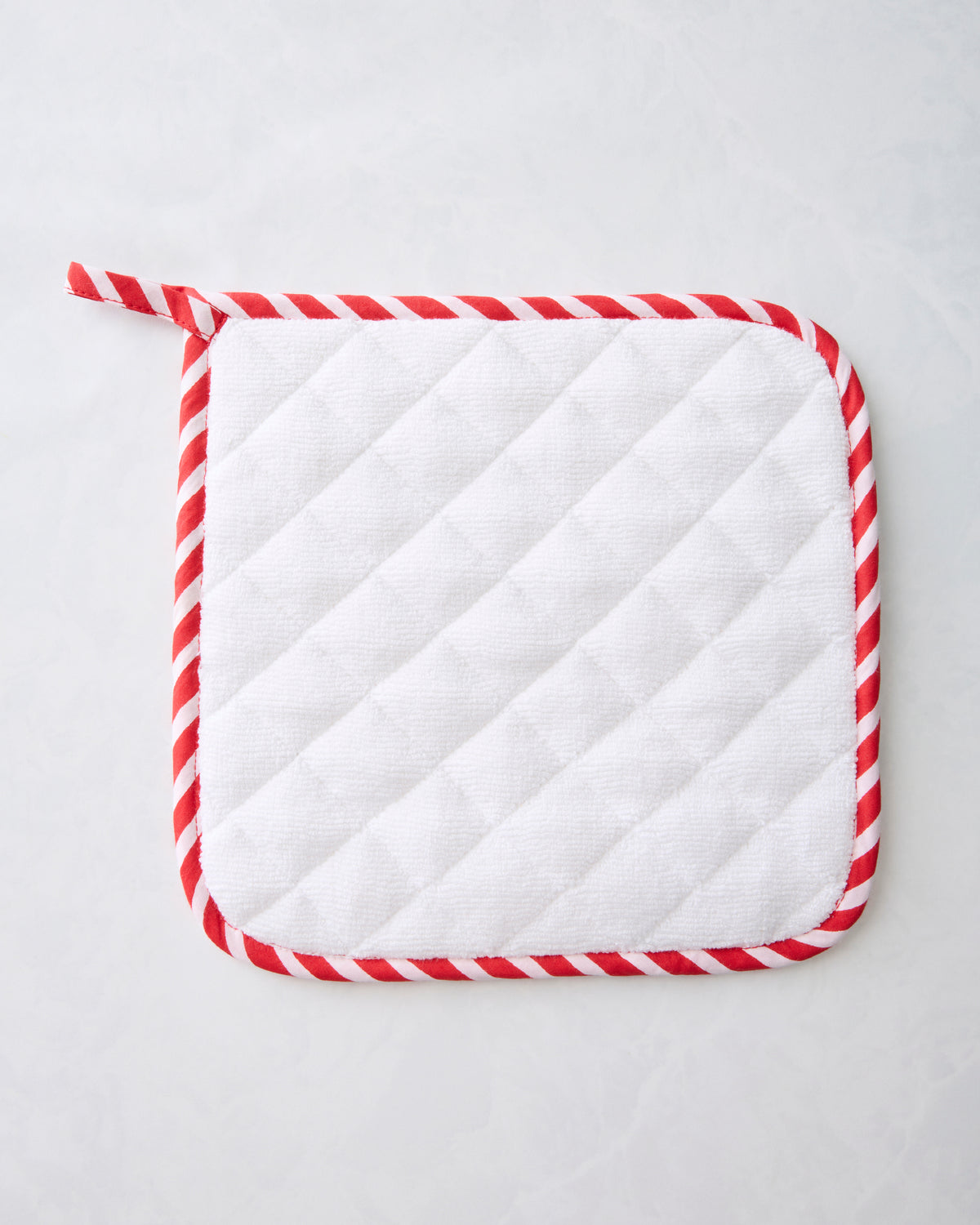 White quilted square pot holder with red-and-white striped trim