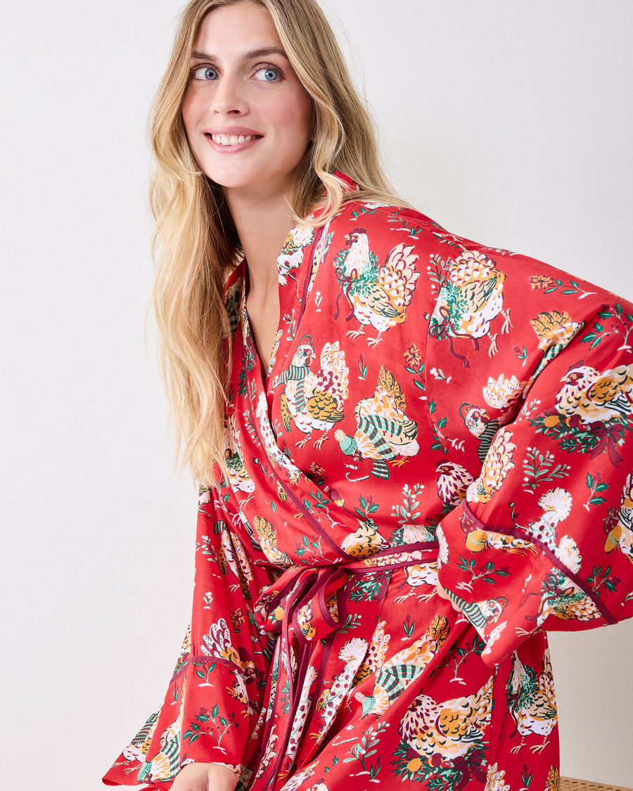 Close-up front view of a red Holiday Hens printed satin robe with a wrap front and tied belt.