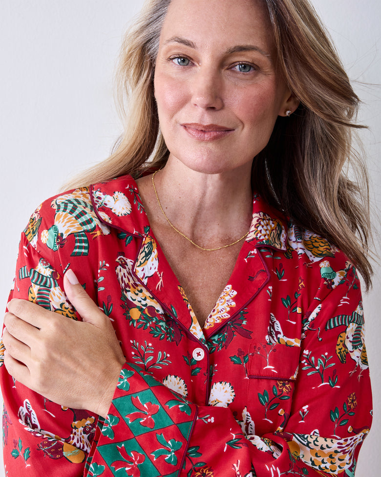 Close-up of a red Holiday Hens pajama top with a notched collar, button front, chest pocket, and holiday chicken pattern.