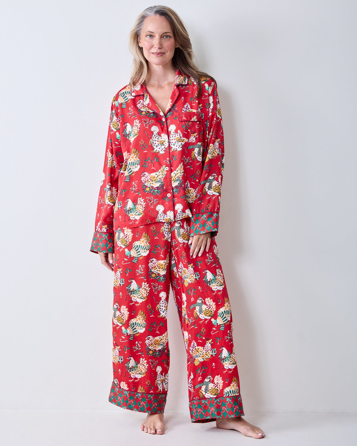 Full front view of a person wearing the red Holiday Hens printed pajama set with a button-down top and wide-leg pants.