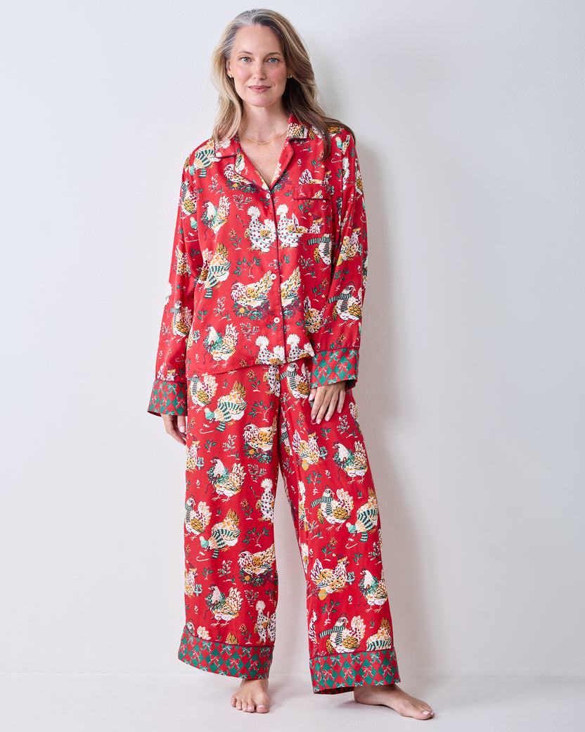 Full front view of a person wearing the red Holiday Hens printed pajama set with a button-down top and wide-leg pants.