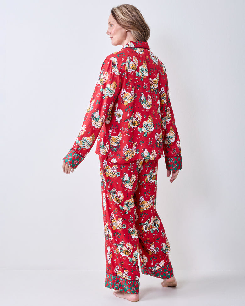 Back view of a person wearing the red Holiday Hens printed pajama set with a button-down top and wide-leg pants.