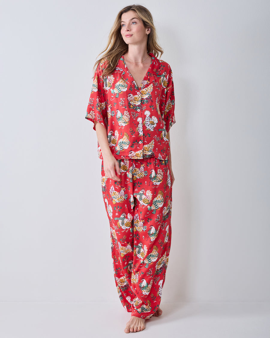 Full-length view of the red Holiday Hens pajama set with a short-sleeve top, matching wide-leg pants, and chicken print