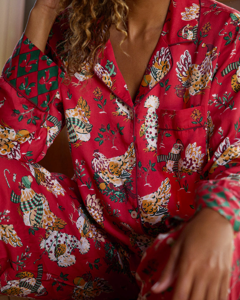 Close-up of the red Holiday Hens pajama top showing the chest pocket, buttons, printed pattern, and contrasting cuff.
