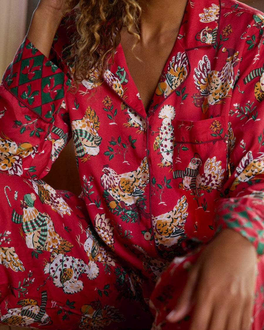 Close-up of the red Holiday Hens pajama top showing the chest pocket, buttons, printed pattern, and contrasting cuff.