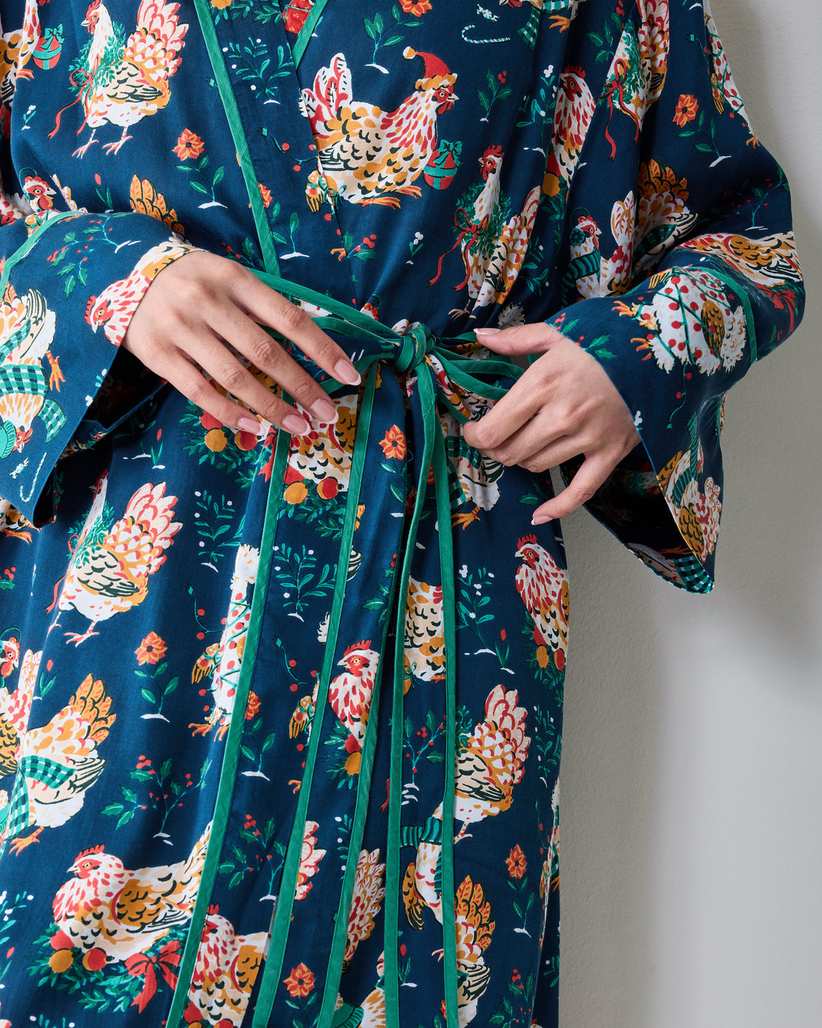 Close-up of the Holiday Hens robe showing the contrasting belt being tied over the chicken print.