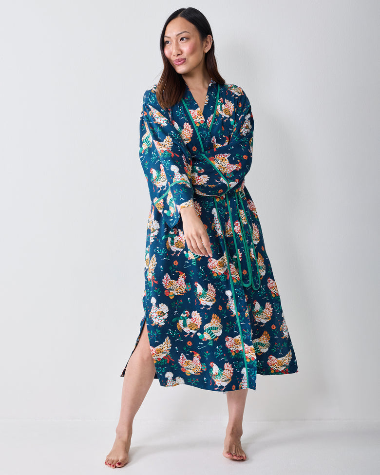 Full-length view of a model wearing the Holiday Hens wrap robe with a contrasting belt and chicken print.