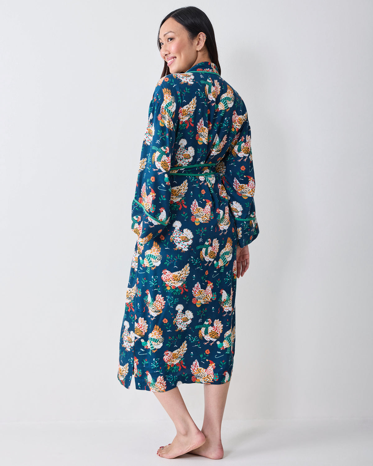 Back view of a person wearing the Holiday Hens satin robe with a dark blue chicken print, long sleeves, and a tied belt.
