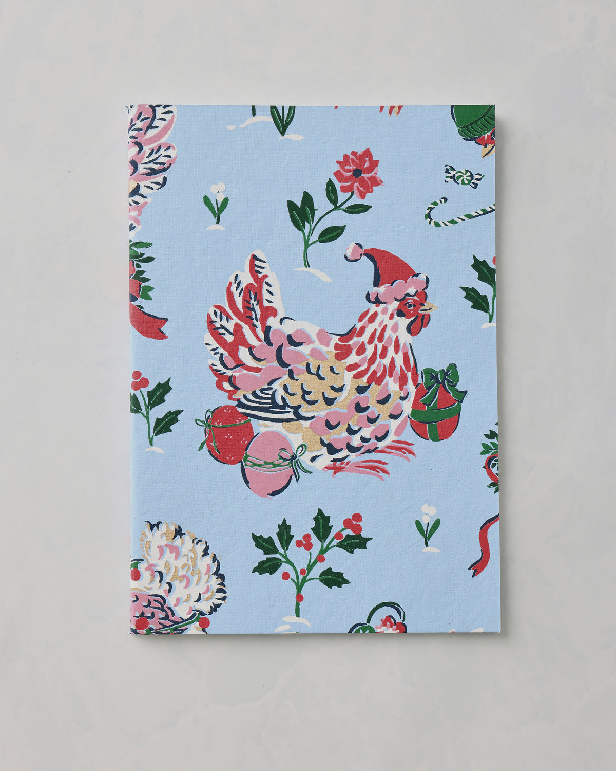 Light blue Holiday Icons notebook cover with a decorated chicken wearing a Santa hat, ornaments, flowers, and holly motifs.