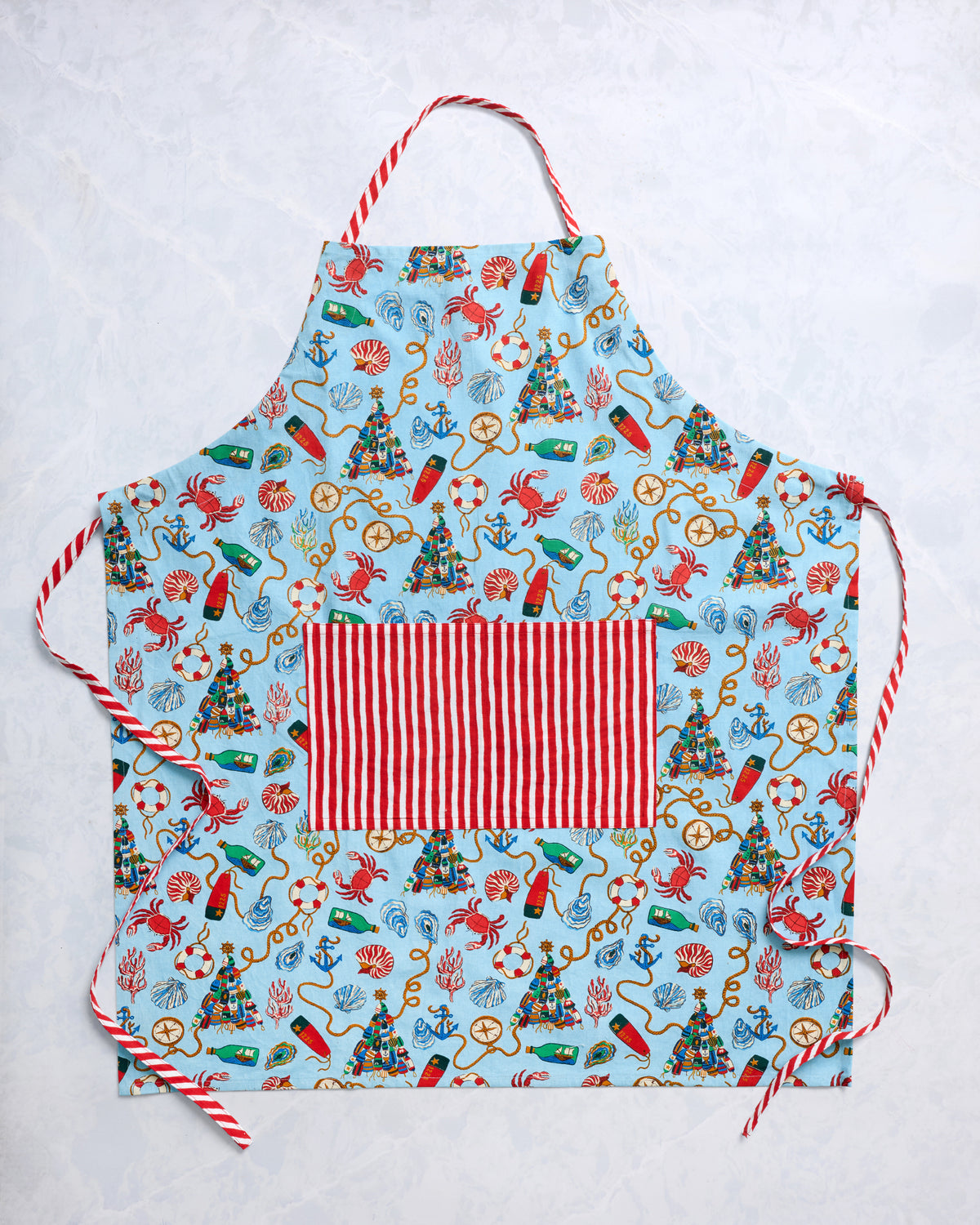 Blue nautical-print apron with a red-and-white striped pocket and matching striped ties, shown flat.