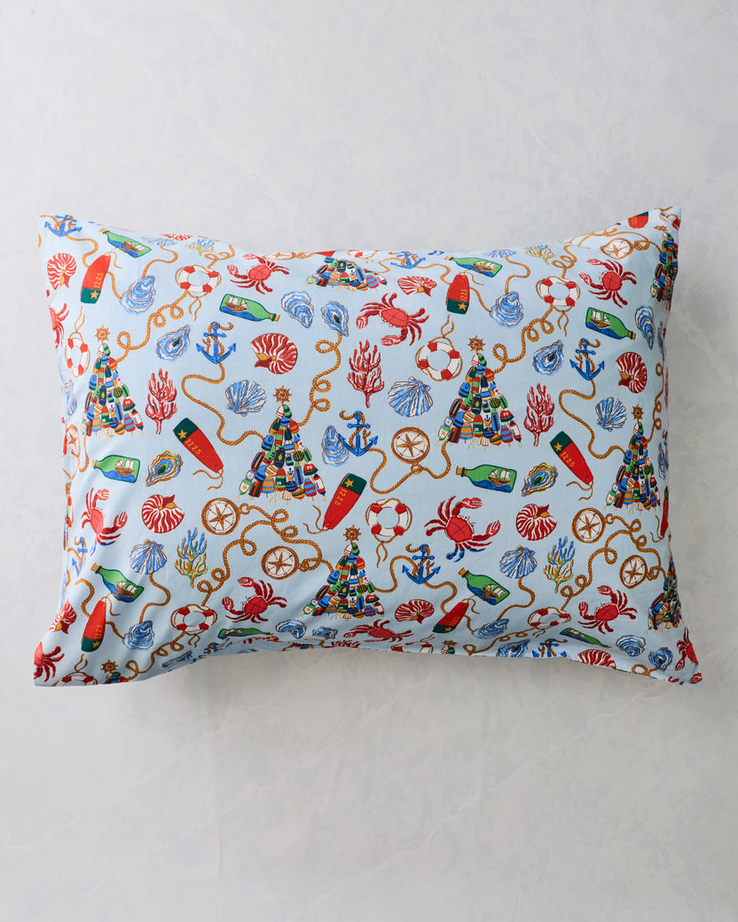 Two pale blue pillowcases with a repeating nautical holiday print, displayed flat against a light background.