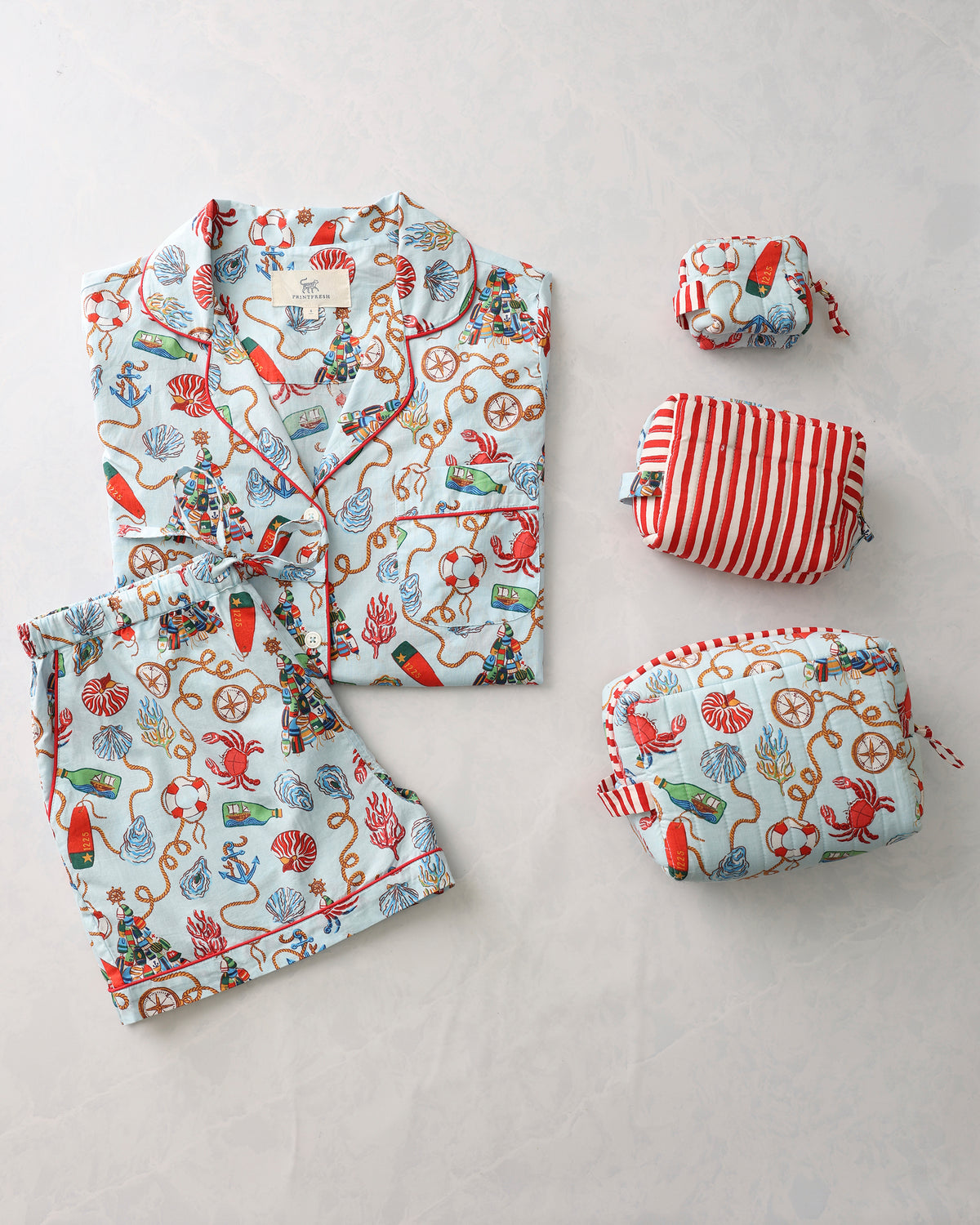 Holidays Ahoy short pajama set with a button-front top, shorts, and three matching pouches.