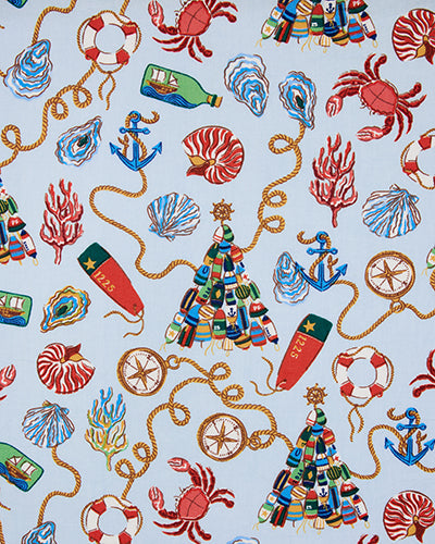 Close-up of the pale blue nautical holiday print featuring crabs, shells, anchors, ropes, bottles, lifebuoys, and holiday trees.