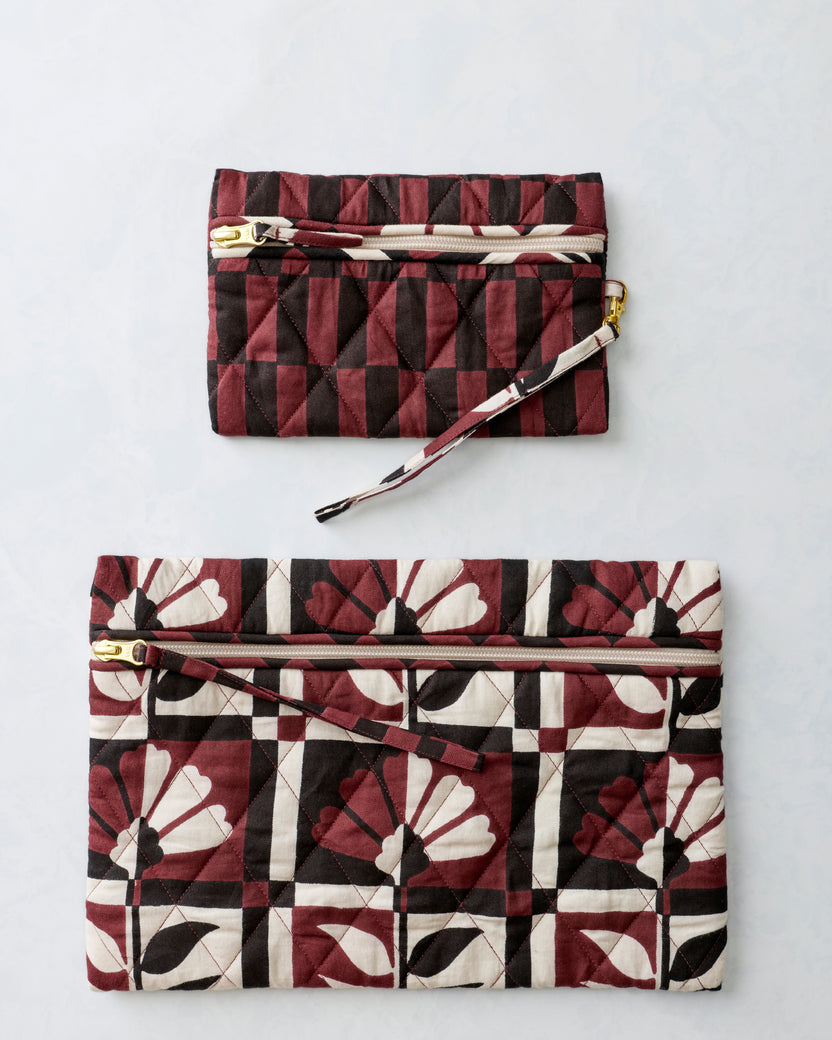 Two quilted zippered pouches shown separately, with the smaller pouch above the larger floral-print pouch.
