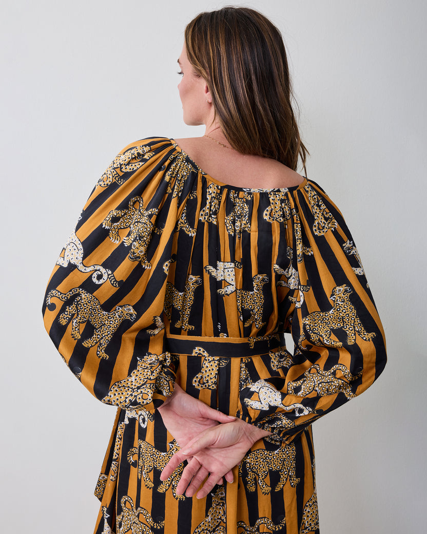 Back view of the Leopard Stripes Felicity dress showing the gathered neckline, long sleeves, waist tie, and printed fabric.