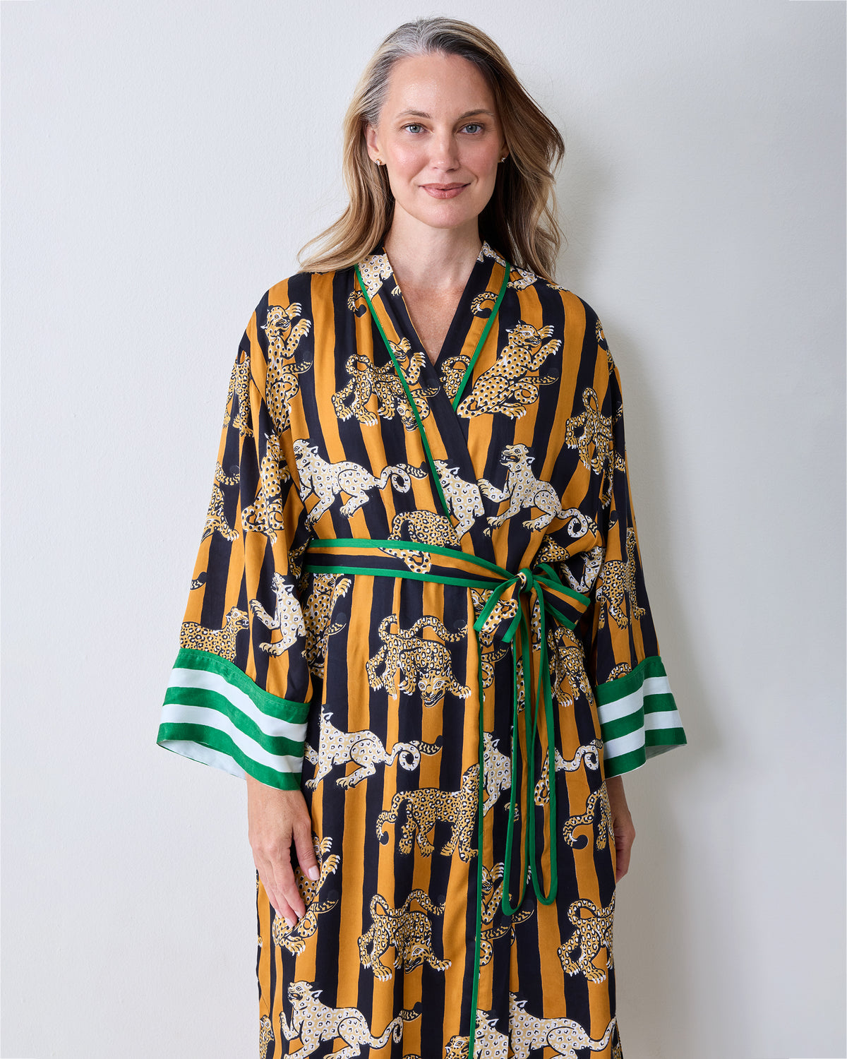 Front view of the butterscotch Leopard Stripes robe with a leopard print, green trim, waist tie, and wide sleeves.