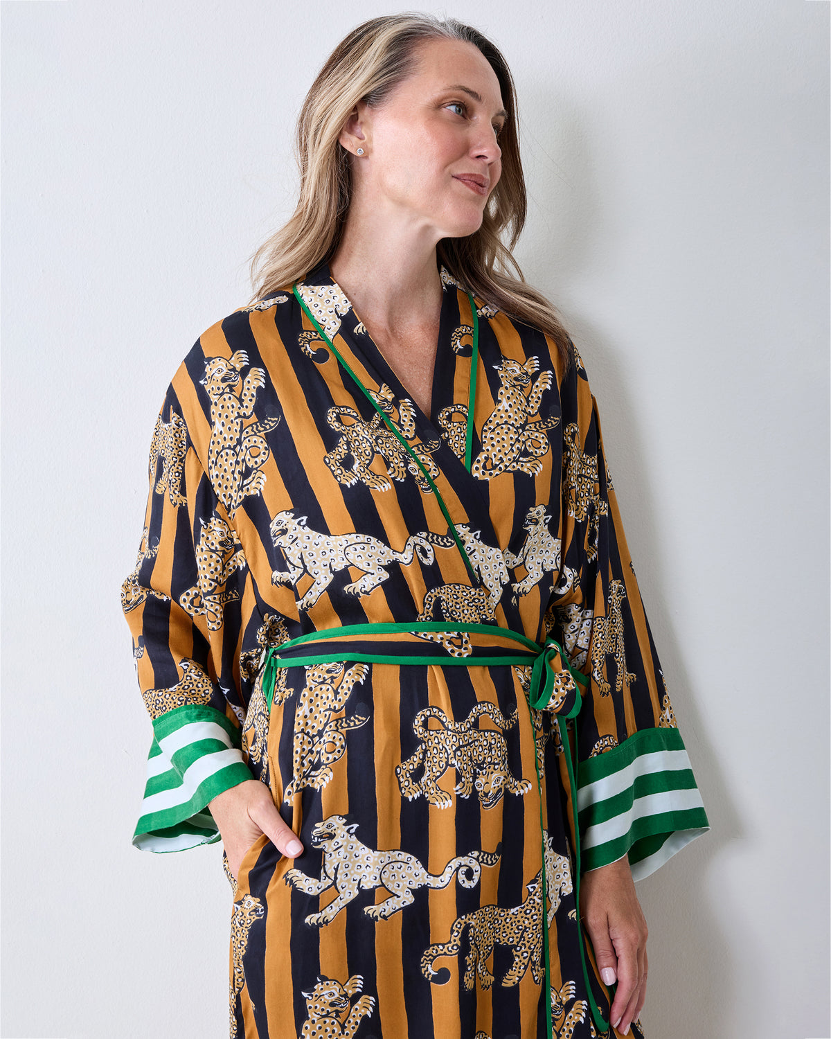 Front view of a leopard stripe robe with a green-trimmed wrap front, matching belt, striped cuffs, and side pockets.