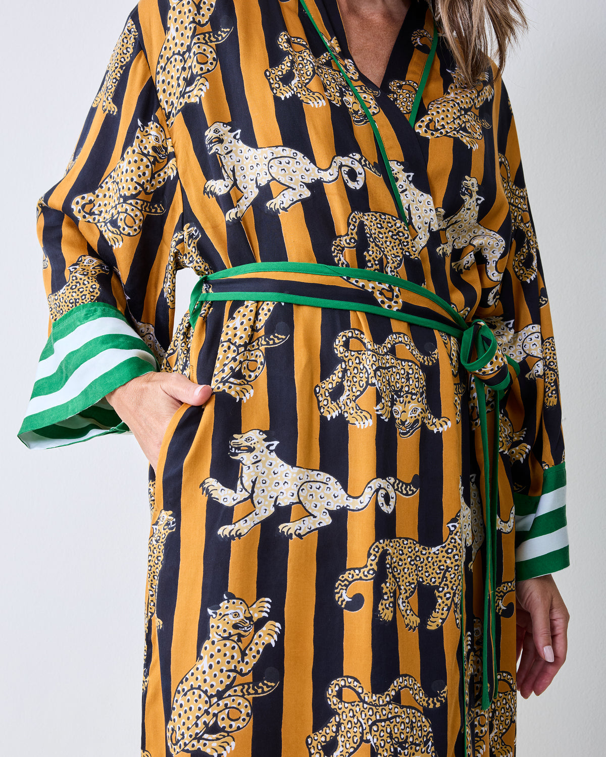 Close view of the butterscotch Leopard Stripes robe showing the leopard print, green waist tie, and side pocket.