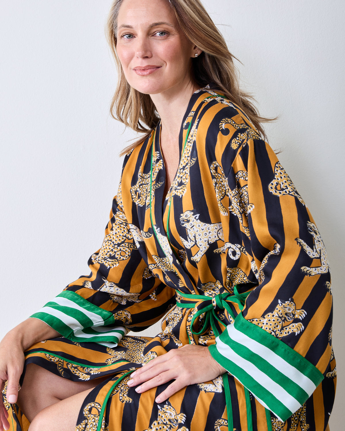 Close-up front view of the striped leopard-print robe showing the waist ties and green-and-white striped cuffs.