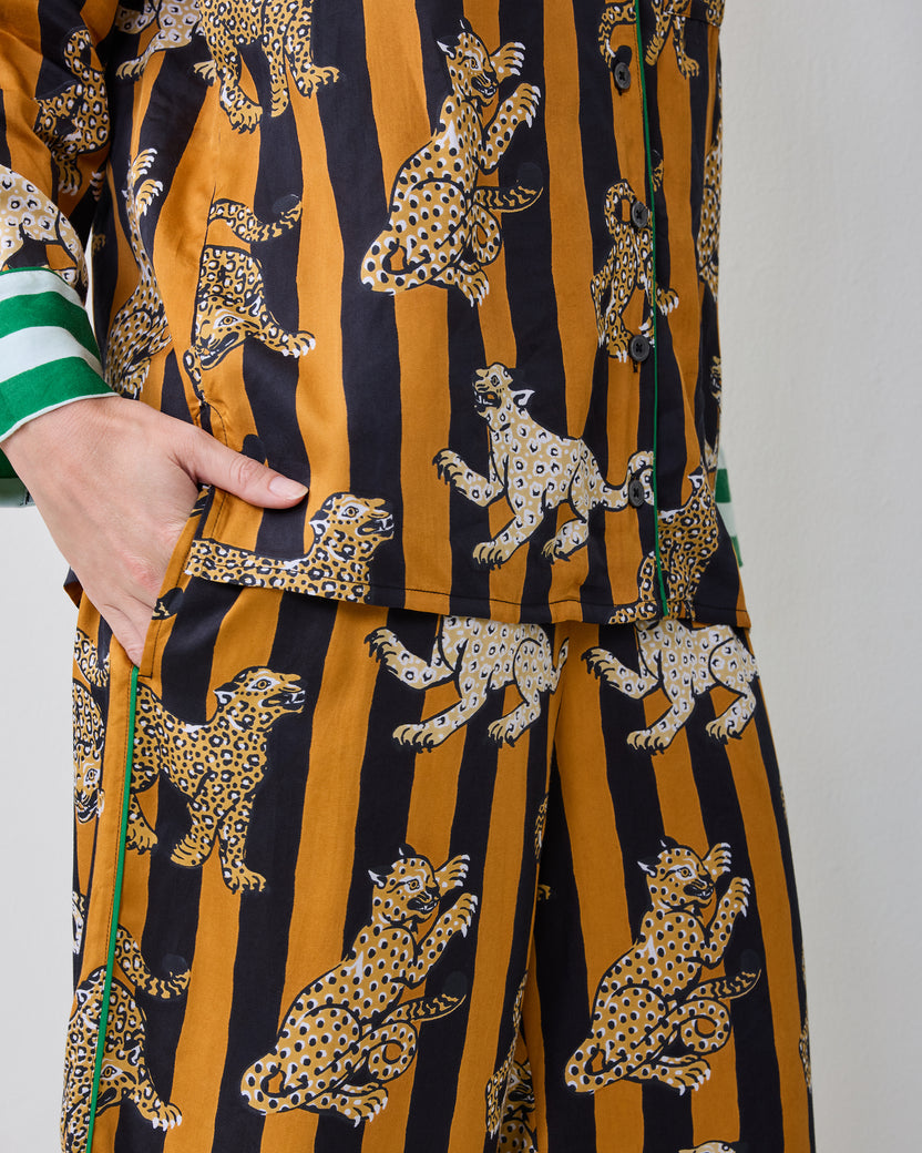 Close-up of the Leopard Stripes Soho pajama top and pants showing the leopard print, button front, piping, and side pocket.