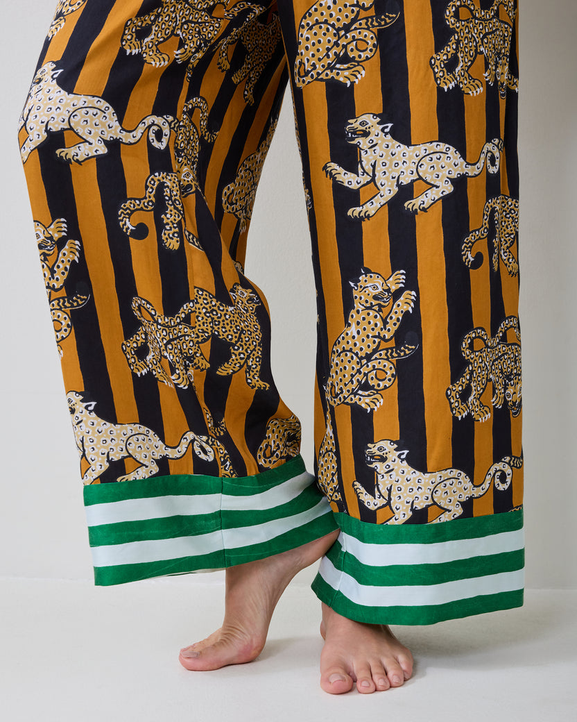 Close-up of the Leopard Stripes Soho pajama pants showing the leopard print and green-and-white striped hems.