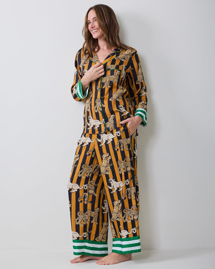Full-length front view of a model wearing the Leopard Stripes Soho pajama set with a button-front top, matching pants, and striped trim.