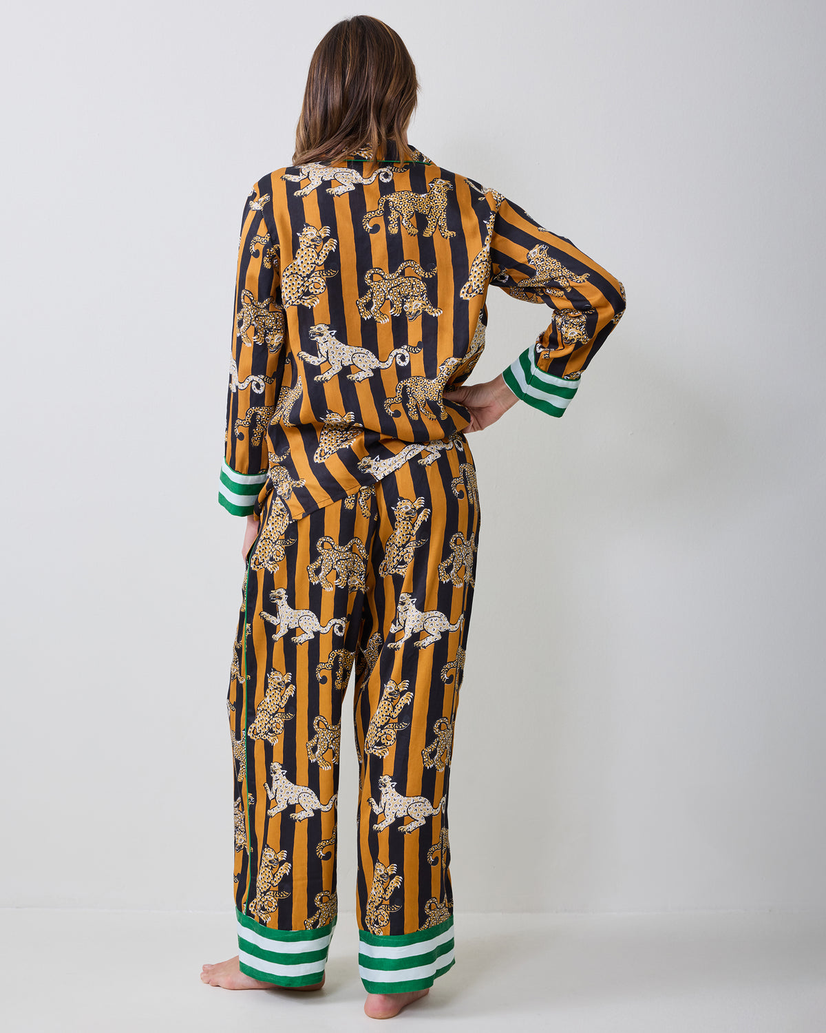 Back view of a model wearing the Leopard Stripes Soho pajama set, showing the matching striped top and pants with green-and-white trim.