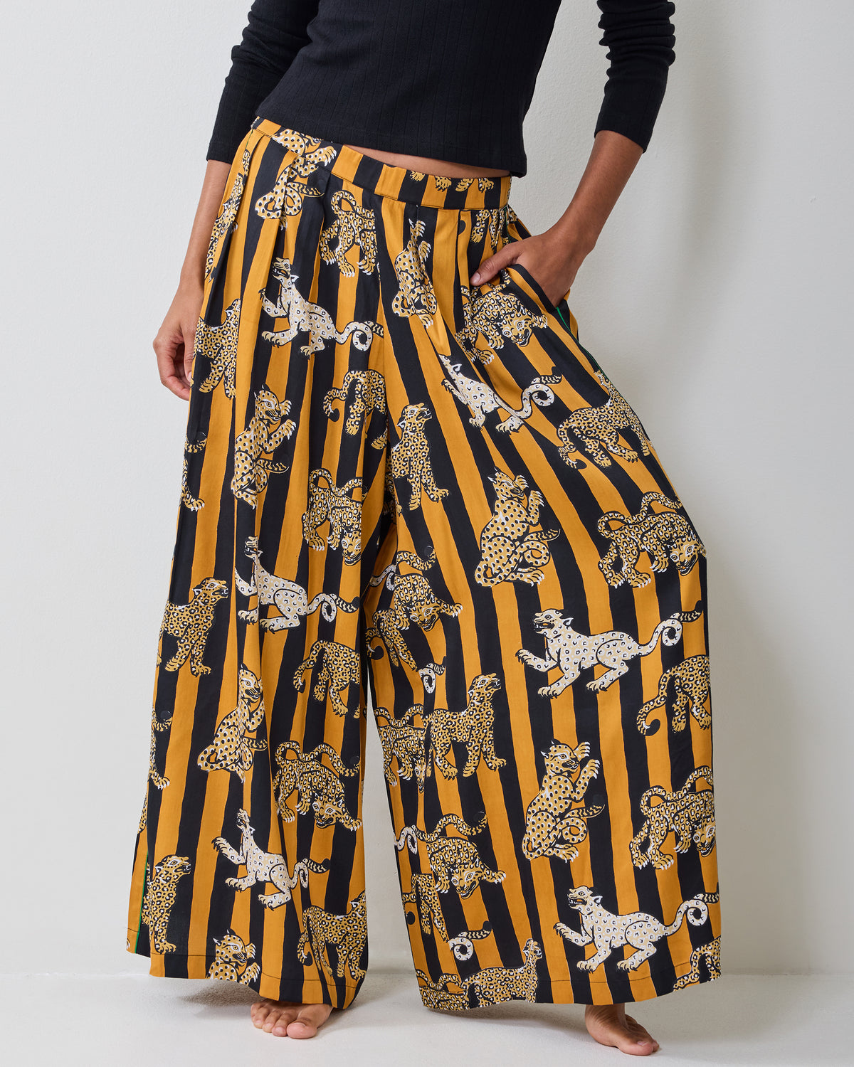 Close view of the Leopard Stripes Tribeca pants showing the elastic waistband, side pockets, wide legs, and leopard print.
