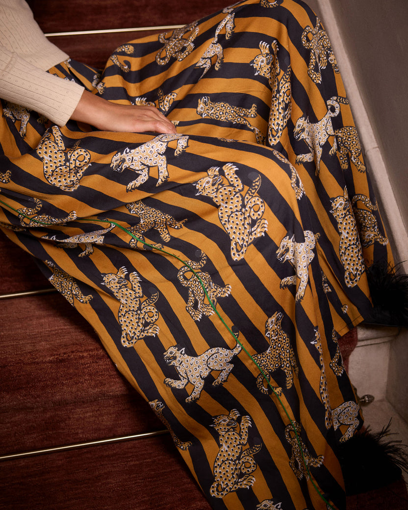 Close-up of the Leopard Stripes Tribeca pants, showing mustard and black vertical stripes with repeated leopard motifs and a green line detail.