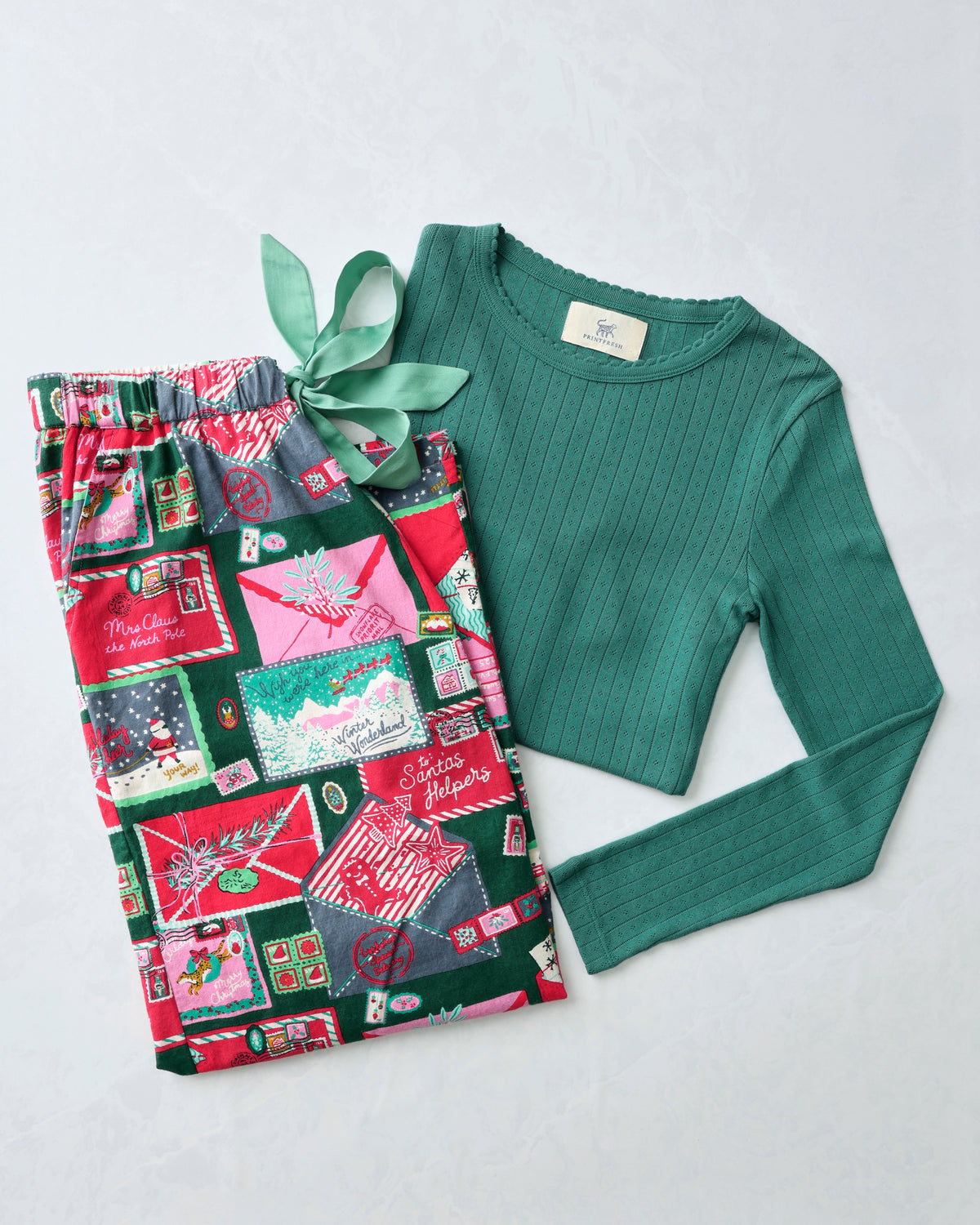 Letters to Santa pajama bundle with patterned pants and a green long-sleeve pointelle top.