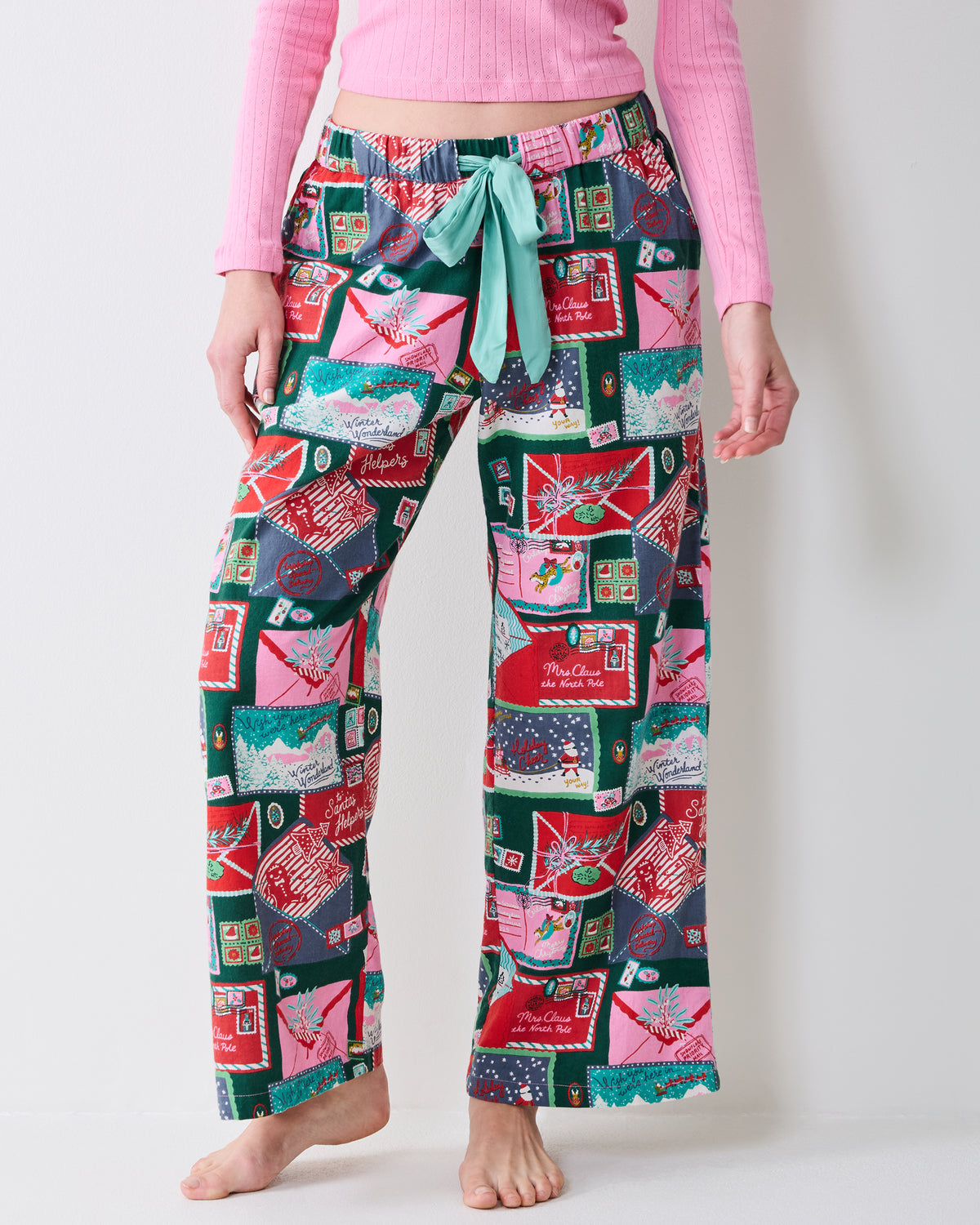 Close view of multicolored patterned pants with a light green drawstring waist and wide legs.