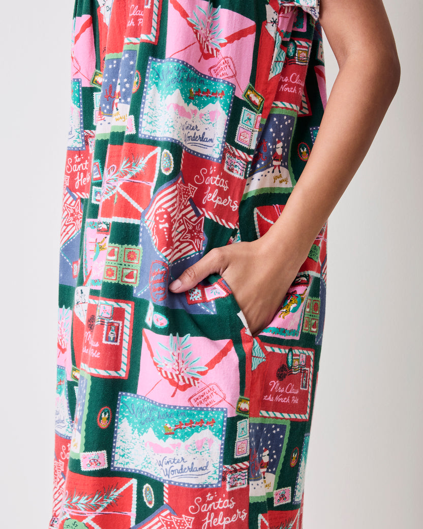 Close-up of the printed nightgown showing a side pocket and holiday envelope, stamp, and winter-scene motifs.
