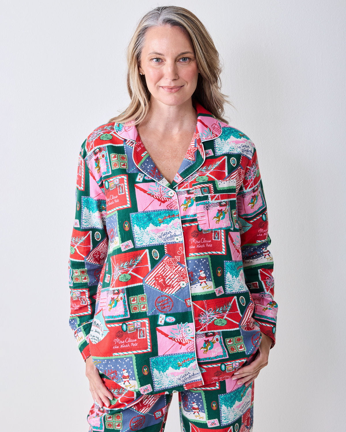 Front upper-body view of the Letters to Santa long pajama set, showing the notched collar, button front, chest pocket, and postcard print.