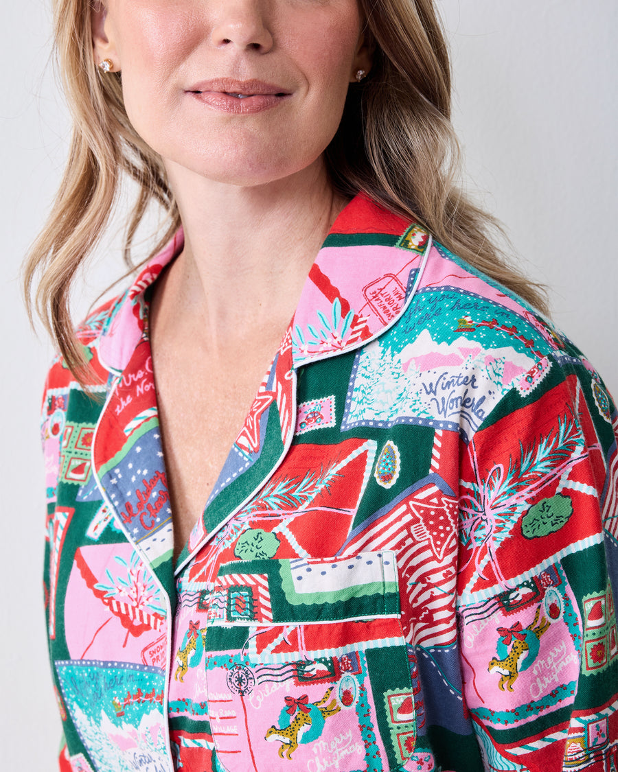 Close-up of the Letters to Santa pajama shirt showing the notched collar, chest pocket, buttons, and printed fabric.