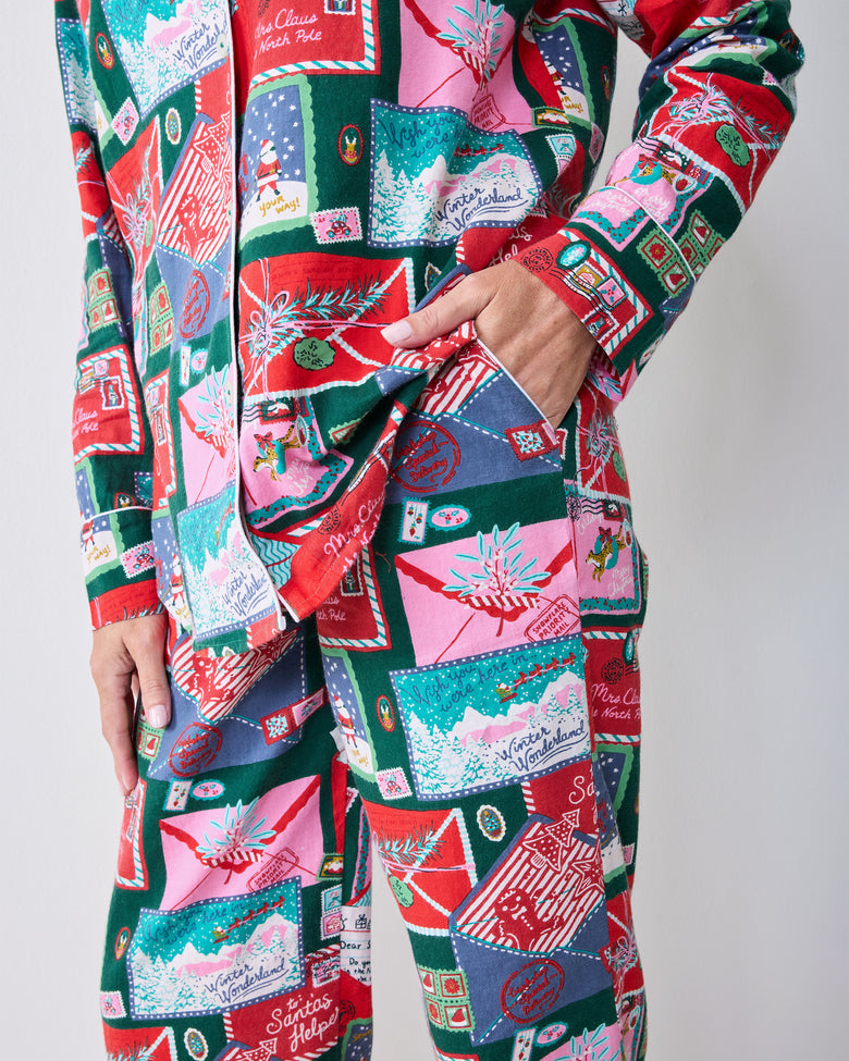 Side detail of the Letters to Santa long pajama set showing the shirt hem, sleeve cuff, side pocket, and matching printed pants.