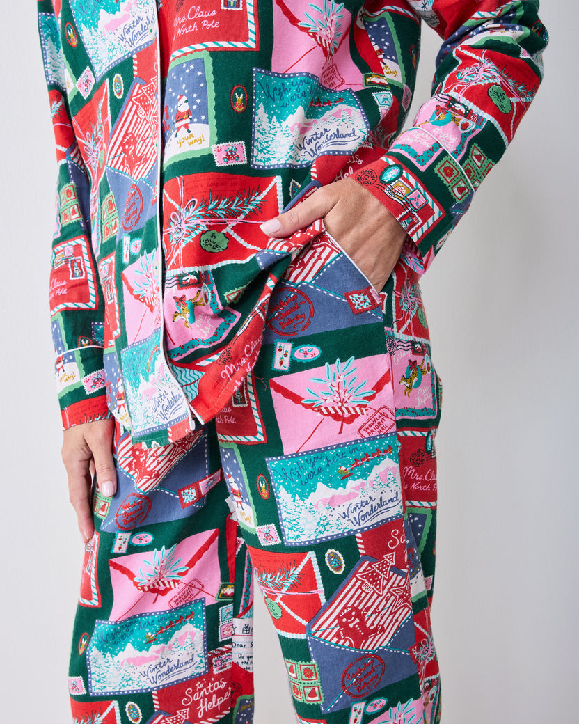 Side detail of the Letters to Santa long pajama set showing the shirt hem, sleeve cuff, side pocket, and matching printed pants.