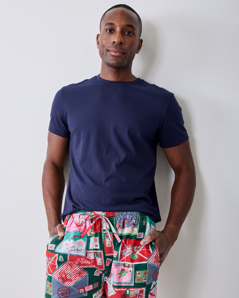 Front view of a person wearing the printed long pajama pants with a navy T-shirt.