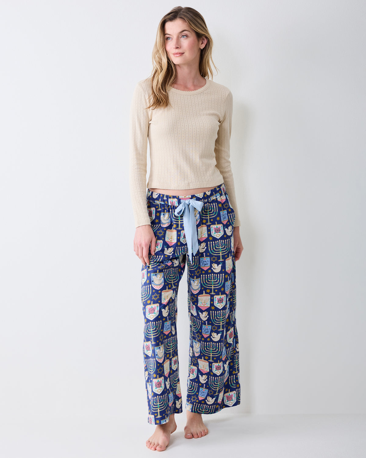 Full-length front view of Hanukkah Blue Astrid wide-leg pajama pants with a light blue drawstring and repeating holiday print.