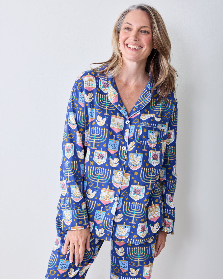 Close-up of a person wearing a blue printed pajama shirt and matching pants