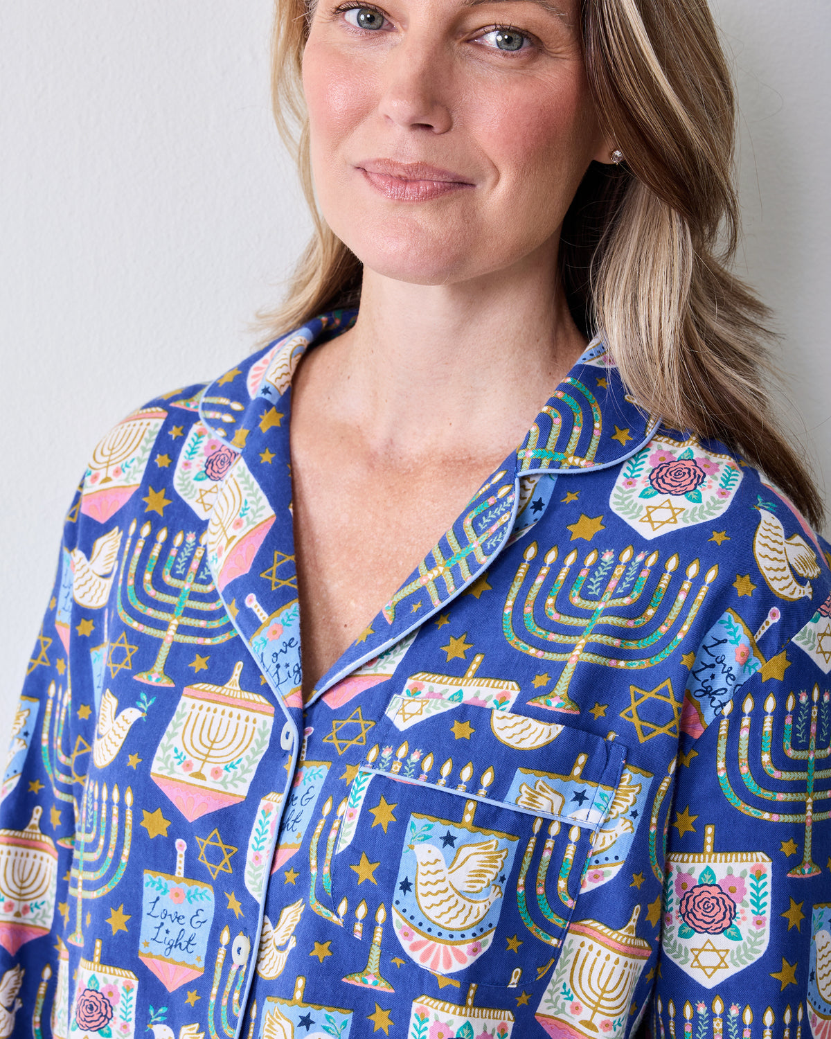 Close-up front view of the blue Love & Light Hanukkah-print pajama top with a notched collar, buttons, and chest pocket.