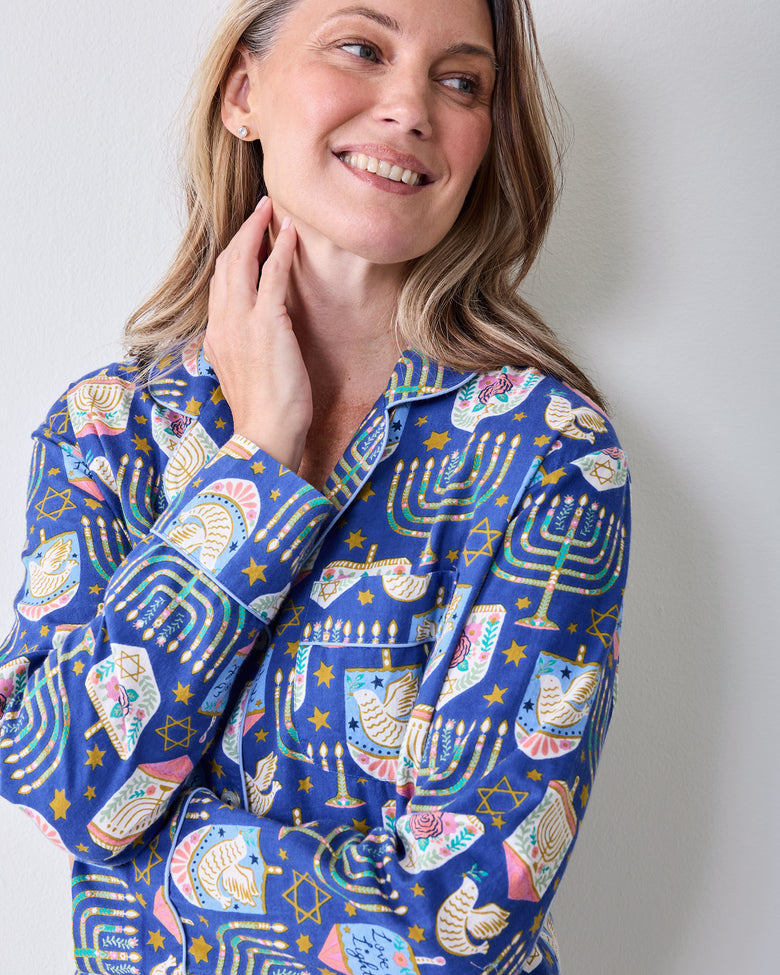 Close-up of a person wearing the blue Love & Light Hanukkah-print pajama top, showing the collar, button front, and long sleeves.