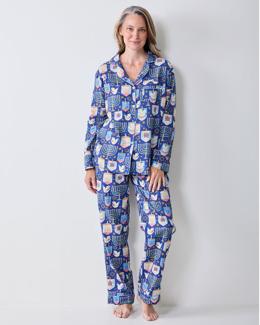 Person wearing a blue long-sleeve pajama set with menorah, dreidel, and Star of David prints