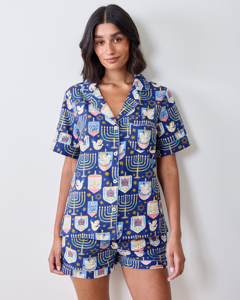 Front view of a blue patterned short pajama set with a collared button-front top and matching shorts.
