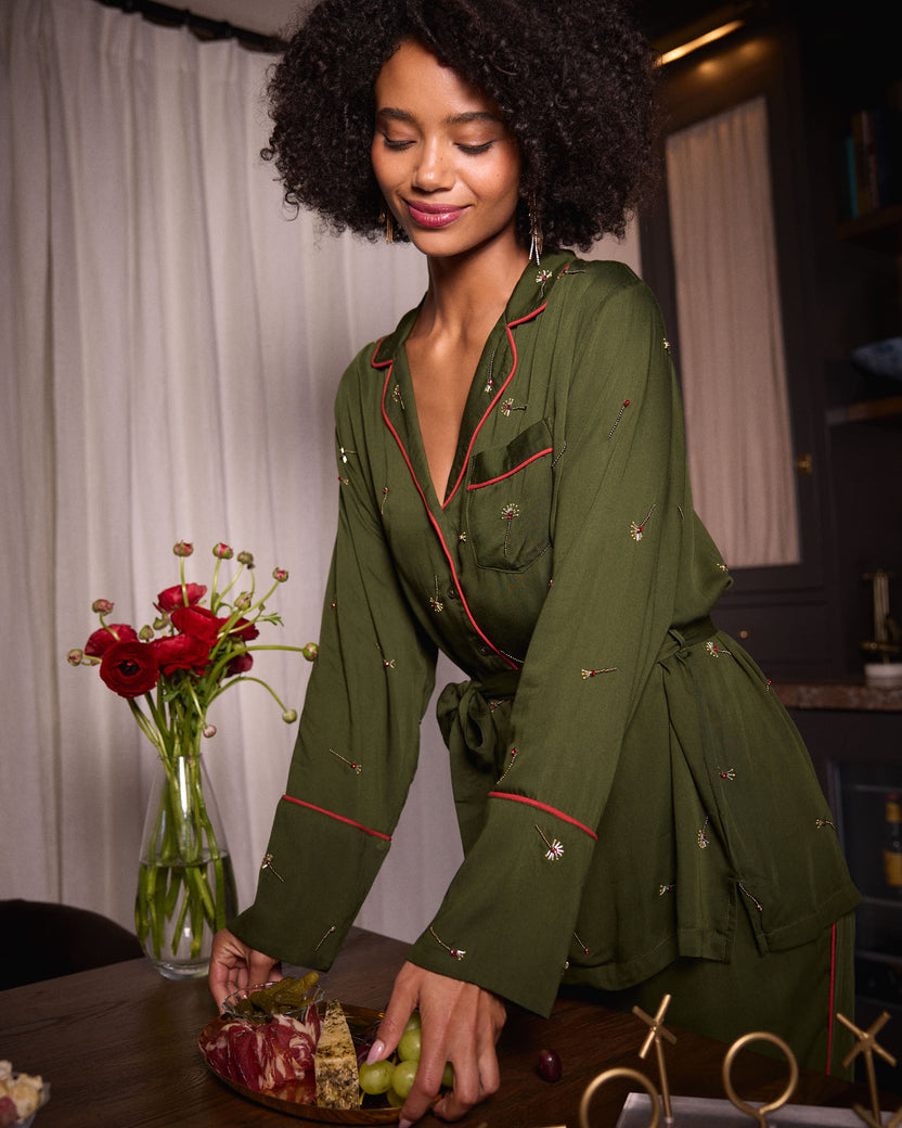 Front view of the olive Matchmaker belted pajama top with red piping, chest pocket, and small decorative motifs.