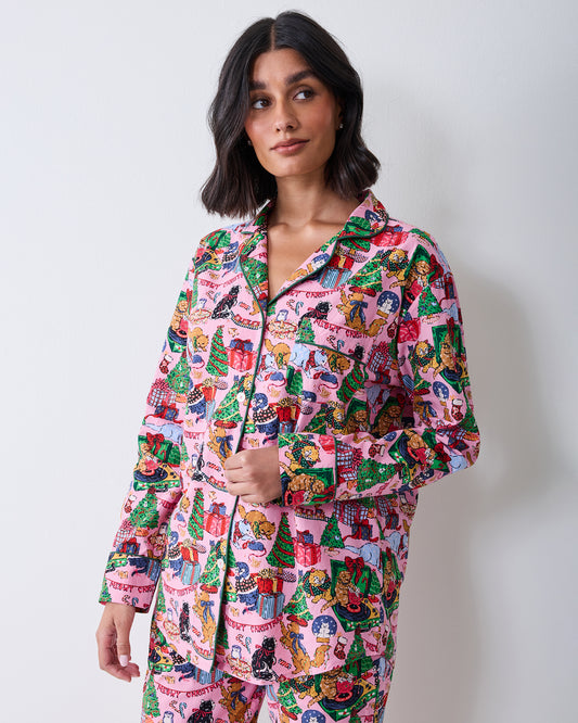 Three-quarter front view of a person wearing the candy pink long pajama set with a collared button-front top and matching Christmas cat print.