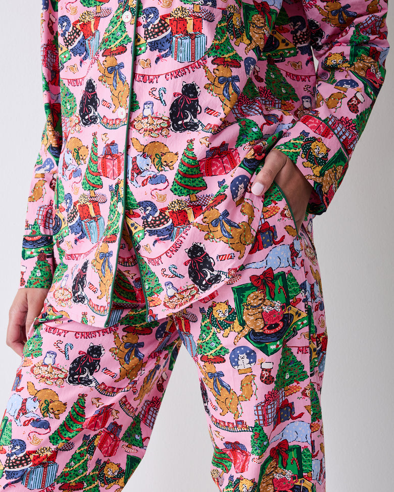 Close detail of the candy pink pajama set showing the button-front top, pocket, matching pants, and Christmas cat print.