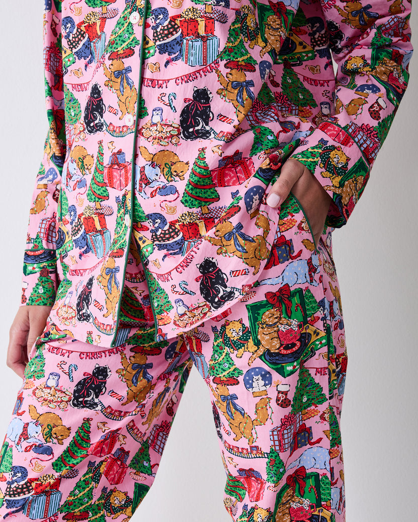 Close detail of the candy pink pajama set showing the button-front top, pocket, matching pants, and Christmas cat print.