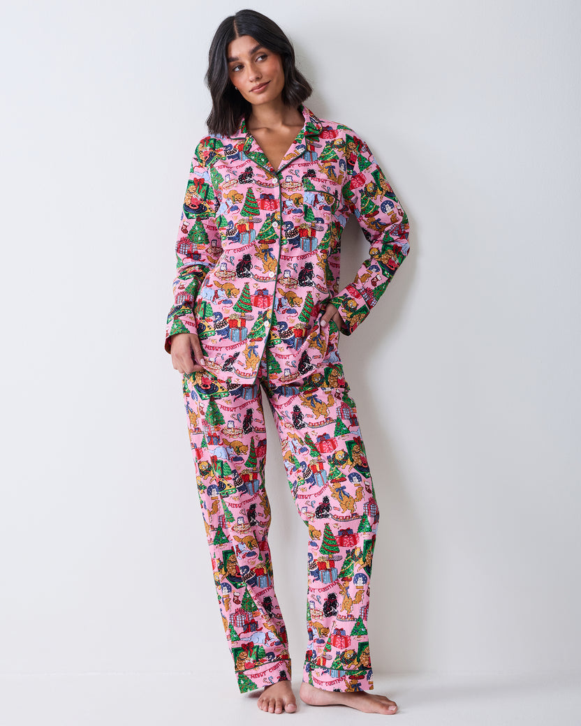 Full front view of a person wearing the candy pink long pajama set with a collared button-front top and matching pants in a Christmas cat print.